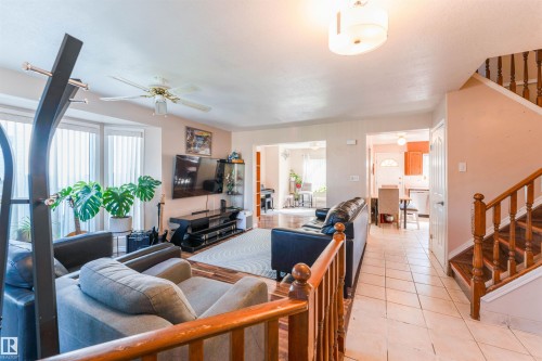 Bay window, ceiling fan, wood-finish flooring, tiled entry, and wood staircase with balusters - 4609 38A Avenue Nw, Edmonton, AB - Indoor Photo Showing Other Room