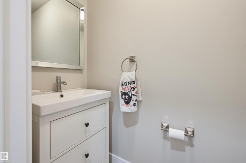 White vanity with a rectangular basin, chrome faucet, and framed mirror - 12219 93 Street Nw, Edmonton, AB - Indoor Photo Showing Bathroom