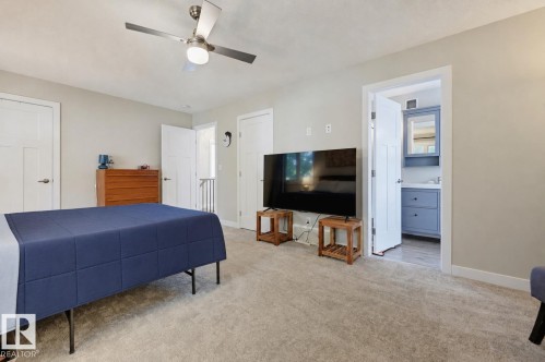 Spacious room with light-colored carpeting, a ceiling fan with integrated lighting, and multiple white paneled doors - 12219 93 Street Nw, Edmonton, AB - Indoor Photo Showing Bedroom
