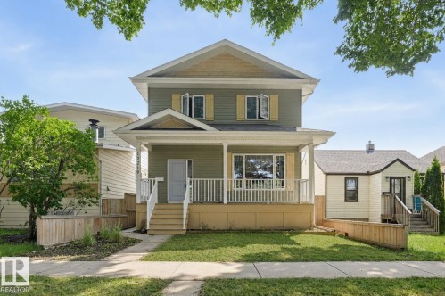 Two-story residence featuring light green siding and a covered front porch with white railings - 12219 93 Street Nw, Edmonton, AB - Outdoor With Deck Patio Veranda