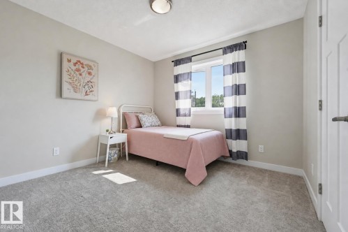 Carpeted room with a double-pane window, neutral wall paint, white trim, and a flush-mount ceiling light - 12219 93 Street Nw, Edmonton, AB - Indoor Photo Showing Bedroom