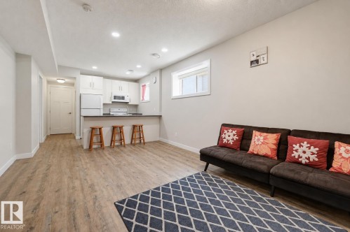 Open-concept living space featuring wood-finish flooring, recessed lighting, and a window - 12219 93 Street Nw, Edmonton, AB - Indoor Photo Showing Living Room