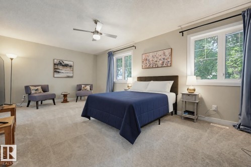 Spacious room with plush carpeting, a ceiling fan, and multiple windows providing natural light - 12219 93 Street Nw, Edmonton, AB - Indoor Photo Showing Bedroom