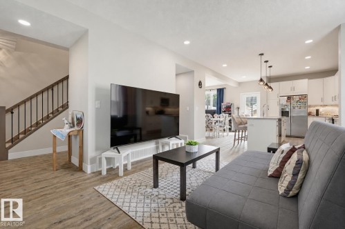 Open-concept living area featuring wood-finish flooring, recessed lighting, and a kitchen island with pendant lighting - 12219 93 Street Nw, Edmonton, AB - Indoor Photo Showing Living Room