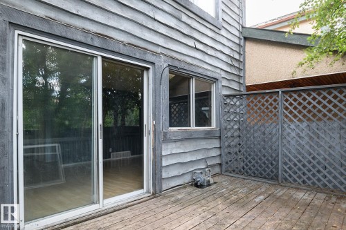 Wood-finish deck with sliding glass door access, lattice fencing, and wood siding - 5511 92C Avenue Nw, Edmonton, AB - Outdoor With Deck Patio Veranda With Exterior