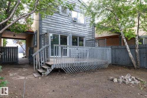 Rear exterior with a wood-finish deck, sliding glass door access, and a fenced perimeter - 5511 92C Avenue Nw, Edmonton, AB - Outdoor With Deck Patio Veranda