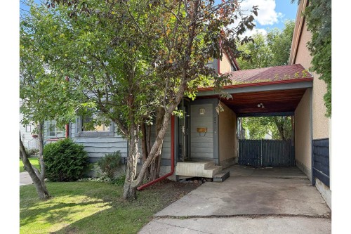 Carport with wood-finish ceiling and concrete driveway - 5511 92C Avenue Nw, Edmonton, AB - Outdoor