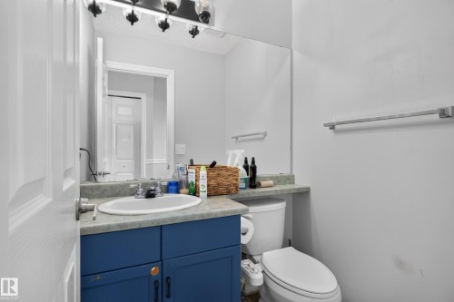 Vanity with an integrated sink, blue cabinetry, and a full-width mirror - 3755 20 Street Nw, Edmonton, AB - Indoor Photo Showing Bathroom