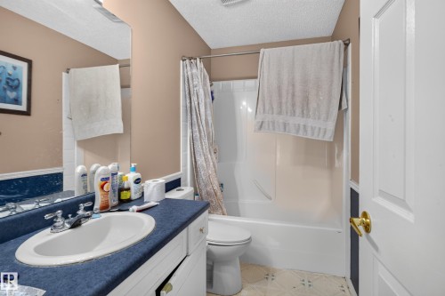 Bathroom featuring a white vanity with a single basin, a full-width mirror, and a shower-tub combination with white surround - 3755 20 Street Nw, Edmonton, AB - Indoor Photo Showing Bathroom