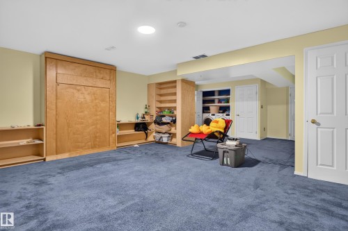 Built-in wood-finish cabinetry, recessed ceiling lighting, and blue carpet flooring - 3755 20 Street Nw, Edmonton, AB - Indoor Photo Showing Other Room