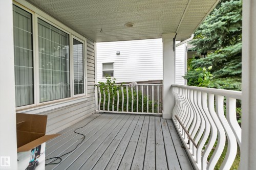 Covered porch with wood-finish decking and white railing - 3755 20 Street Nw, Edmonton, AB - Outdoor With Deck Patio Veranda With Exterior