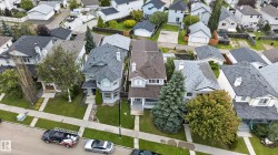 Gable rooflines with asphalt shingles, mature trees, and landscaping - 