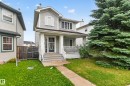 Two-story residence featuring light gray siding, an inviting covered front porch with white railings, a concrete front path, and established evergreen landscaping - 3755 20 Street Nw, Edmonton, AB  - Outdoor With Deck Patio Veranda 
