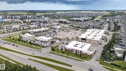 Expansive commercial properties with ample surface parking, surrounded by residential developments and major roadways - 