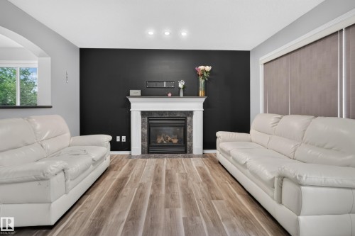 Fireplace with stone surround and classic mantel - 3755 20 Street Nw, Edmonton, AB - Indoor Photo Showing Living Room With Fireplace