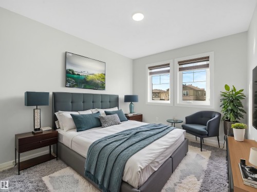 Recessed ceiling lighting, dual pane windows with blinds, and wall-mounted television - 203 Cavanagh Common Sw, Edmonton, AB - Indoor Photo Showing Bedroom