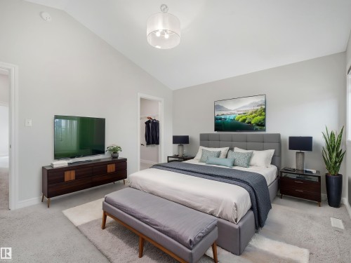 Vaulted ceiling, recessed lighting, neutral wall tones, carpeted flooring, and a walk-in closet - 203 Cavanagh Common Sw, Edmonton, AB - Indoor Photo Showing Bedroom