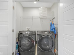 Laundry closet with front-load machines, overhead wire shelving, and recessed lighting - 