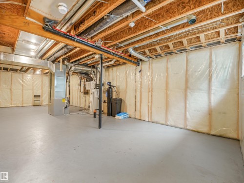 Unfinished basement featuring exposed wood joists and subflooring, insulated walls, and a concrete floor - 203 Cavanagh Common Sw, Edmonton, AB - Indoor Photo Showing Basement