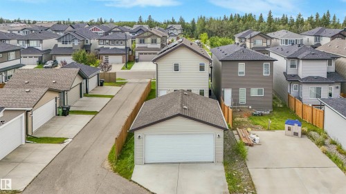 Detached garage with asphalt shingle roof, concrete driveway, and wood fencing - 203 Cavanagh Common Sw, Edmonton, AB - Outdoor