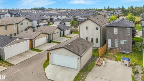 Detached garage with a pitched roof, light-colored siding, and a concrete driveway - 203 Cavanagh Common Sw, Edmonton, AB - Outdoor