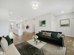 Open-concept living space featuring wood-finish flooring, recessed lighting, and a kitchen island with pendant lighting - 