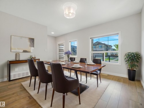 Recessed lighting, wood-finish flooring, white window frames, and a glass-enclosed light fixture - 203 Cavanagh Common Sw, Edmonton, AB - Indoor Photo Showing Dining Room