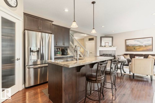 Kitchen island with granite countertop and pendant lighting - 22 Voleta Crest, Spruce Grove, AB - Indoor Photo Showing Kitchen With Stainless Steel Kitchen With Upgraded Kitchen