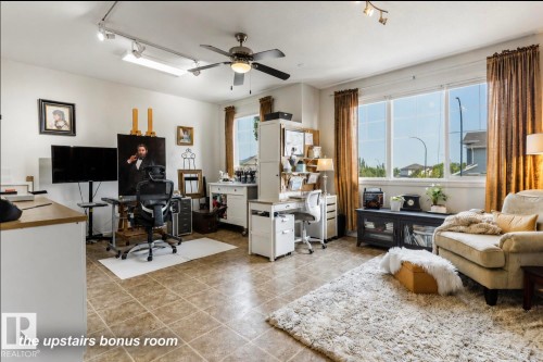 Spacious bonus room featuring large windows, neutral tile flooring, a ceiling fan with integrated lighting, and track lighting fixtures - 22 Voleta Crest, Spruce Grove, AB - Indoor Photo Showing Office
