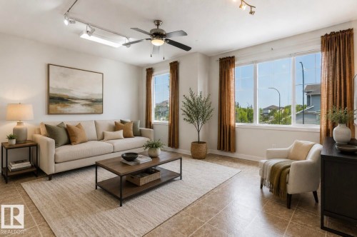 Living area featuring tile flooring, a ceiling fan, track lighting, multiple large windows, and a neutral color palette - 22 Voleta Crest, Spruce Grove, AB - Indoor Photo Showing Living Room