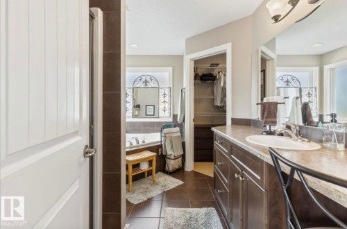 Spacious bathroom featuring a built-in soaking tub, dual windows, and a generous vanity with integrated sink - 22 Voleta Crest, Spruce Grove, AB - Indoor Photo Showing Bathroom