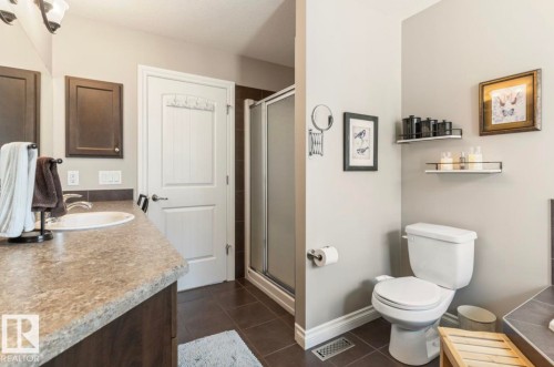 Functional bathroom featuring a single vanity with a laminate countertop, dark wood-finish cabinetry, and an integrated sink - 22 Voleta Crest, Spruce Grove, AB - Indoor Photo Showing Bathroom
