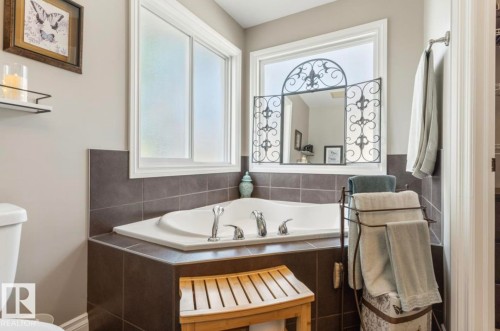 Corner soaking tub with tile surround, dual windows, and brushed nickel fixtures - 22 Voleta Crest, Spruce Grove, AB - Indoor Photo Showing Bathroom