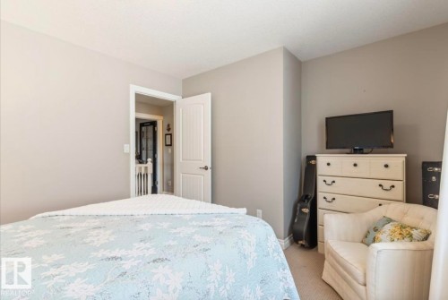 Carpeted bedroom with neutral wall tones and a white paneled door - 22 Voleta Crest, Spruce Grove, AB - Indoor Photo Showing Bedroom