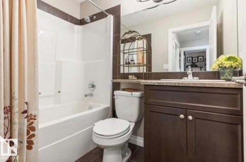 Bathroom featuring a dark wood-finish vanity with a light countertop, an integrated sink, and a chrome faucet - 22 Voleta Crest, Spruce Grove, AB - Indoor Photo Showing Bathroom