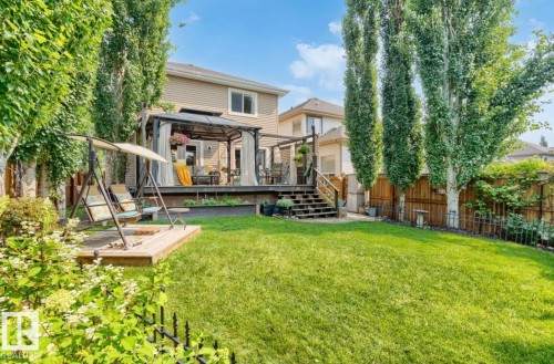 Expansive backyard featuring a lush lawn, mature trees, and a multi-level deck with a covered gazebo - 22 Voleta Crest, Spruce Grove, AB - Outdoor With Deck Patio Veranda