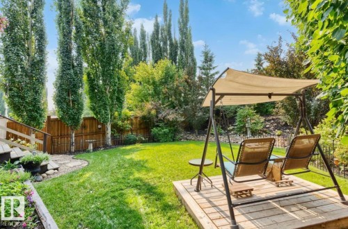 Expansive backyard featuring a lush lawn and a wood deck platform - 22 Voleta Crest, Spruce Grove, AB - Outdoor With Deck Patio Veranda With Backyard