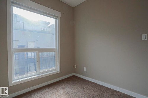 Dual-pane window with white trim, light gray wall finish, and neutral-toned carpeting - #607 10518 113 St Nw Nw, Edmonton, AB - Indoor Photo Showing Other Room