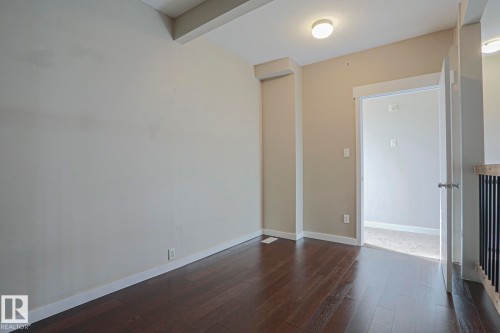 Hardwood flooring, painted walls, ceiling light fixture, framed doorway, and white trim - #607 10518 113 St Nw Nw, Edmonton, AB - Indoor Photo Showing Other Room