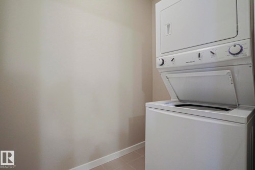 Stacked white washer and dryer unit - #607 10518 113 St Nw Nw, Edmonton, AB - Indoor Photo Showing Laundry Room