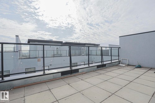 Rooftop deck with square paver tiles and glass panel railing - #607 10518 113 St Nw Nw, Edmonton, AB - Outdoor With Balcony