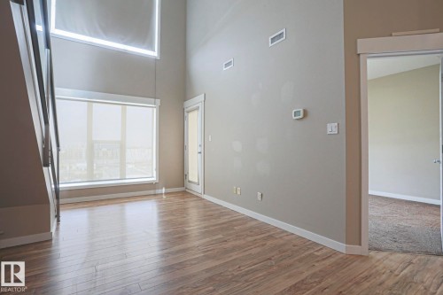 High ceilings complementing wood-finish flooring - #607 10518 113 St Nw Nw, Edmonton, AB - Indoor Photo Showing Other Room