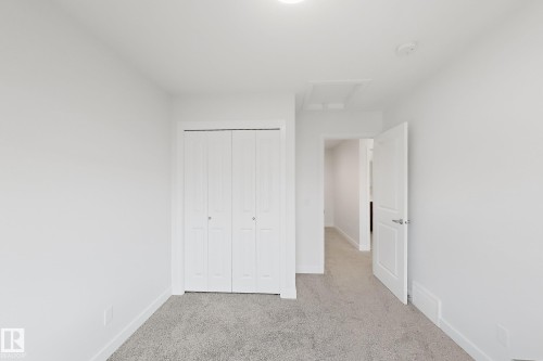White bi-fold closet doors with brushed nickel hardware - 7791 Eifert Crescent Nw, Edmonton, AB - Indoor