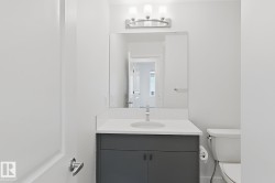 Modern vanity featuring a white countertop, undermount sink, and matte gray cabinetry - 