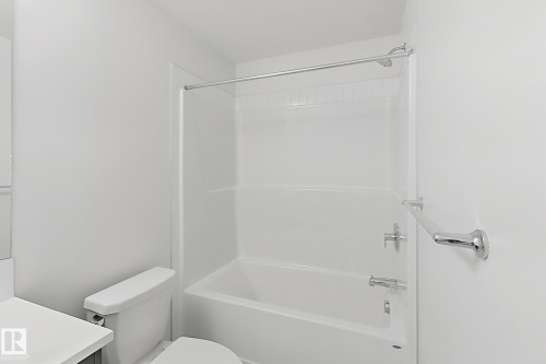 Full-sized tub and shower combination with white tile surround - 7791 Eifert Crescent Nw, Edmonton, AB - Indoor Photo Showing Bathroom
