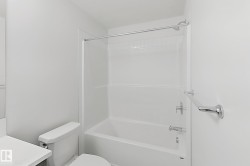 Full-sized tub and shower combination with white tile surround - 