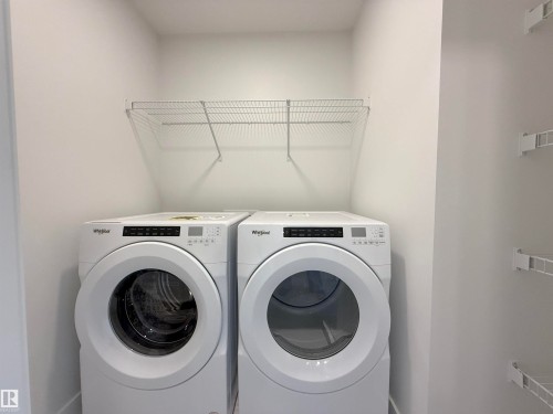 Dedicated laundry area featuring front-loading washer and dryer units - 7791 Eifert Crescent Nw, Edmonton, AB - Indoor Photo Showing Laundry Room