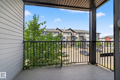 Outdoor concrete patio with black metal railings and a textured ceiling - 3353 16A Avenue Nw, Edmonton, AB - Outdoor With Exterior