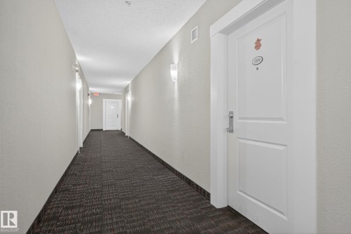 Textured wall finish, recessed lighting, wall-mounted sconces, patterned carpet flooring, and white paneled doors - 3353 16A Avenue Nw, Edmonton, AB - Indoor Photo Showing Other Room