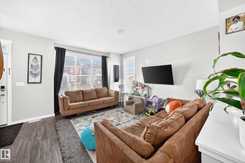 Recessed ceiling lighting, white trim work, large windows with blinds, wood-finish flooring, and light wall paint - 1929 24 Street Nw, Edmonton, AB - Indoor Photo Showing Living Room